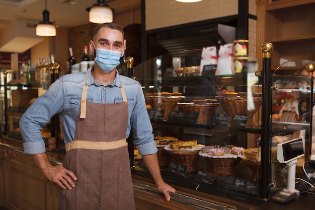 Handsome young employee in a bakery shop