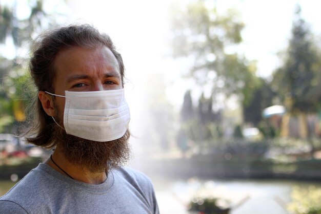 Foto un bel giovane europeo con una maschera per proteggersi dal coronavirus e da altre infezioni