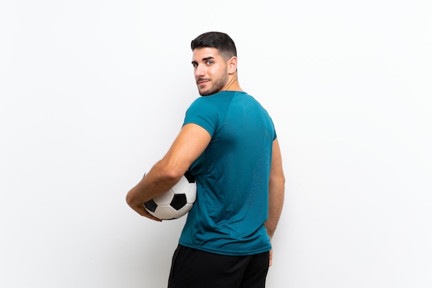 Handsome young football player man over isolated white wall 