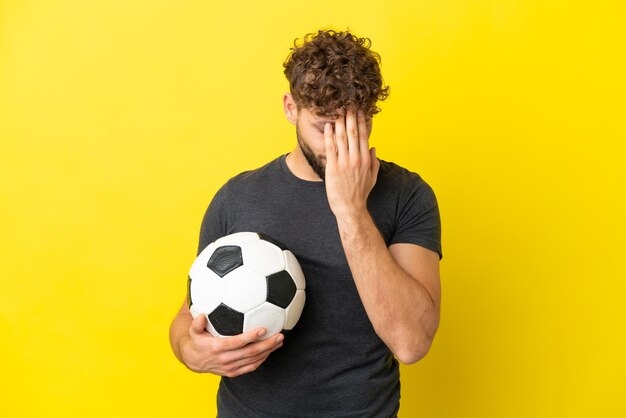 Handsome young football player man isolated on yellow background with tired and sick expression