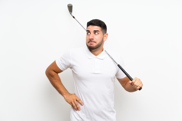 Il giovane uomo bello del giocatore di giocatore di golf sul bianco che fa i dubbi fa gesto mentre solleva le spalle