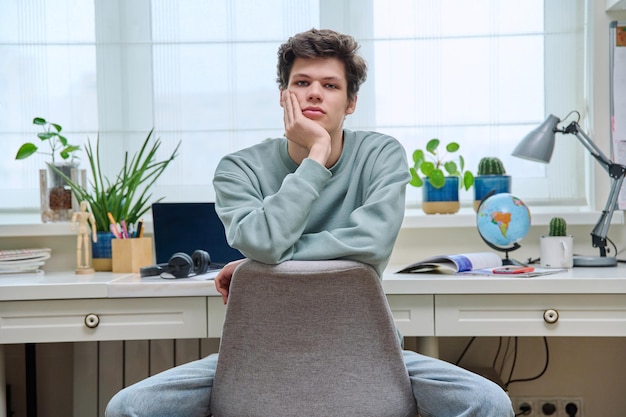 Handsome young guy sitting in home interior