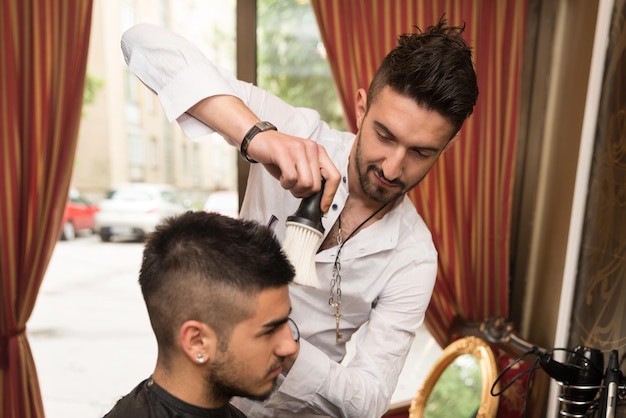 Handsome Young Hairdresser Giving A New Haircut To Male Customer At Parlor