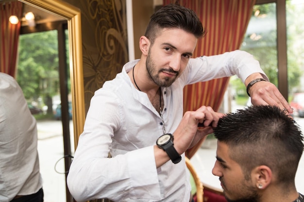 Handsome Young Hairdresser Giving A New Haircut To Male Customer At Parlor