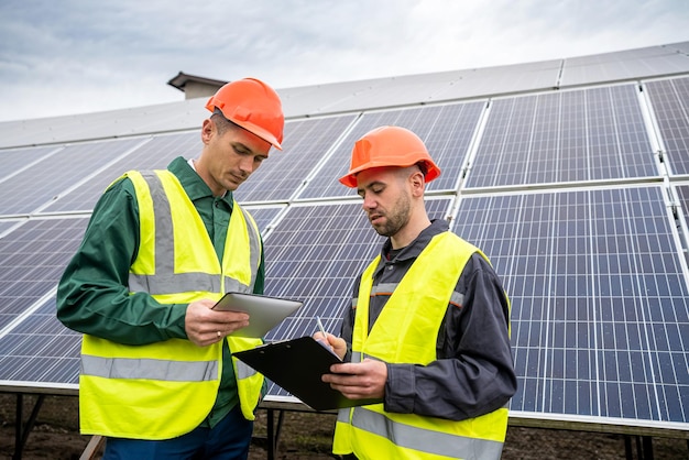 Handsome young healthy guys workers working on installing solar panel construction Green electricity concept