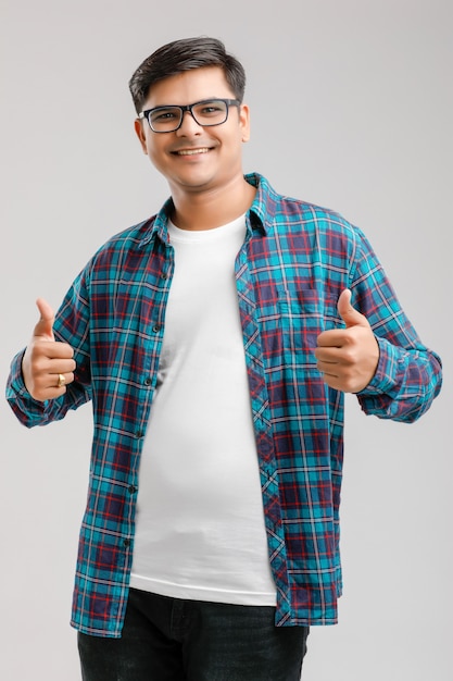 Handsome young Indian man showing thumps up isolated