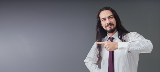 Handsome young Italian man is showing the empty space with his hands includes copy space