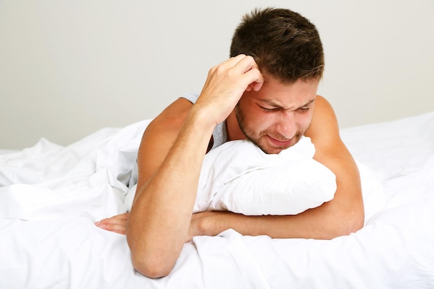 Handsome young man in bed