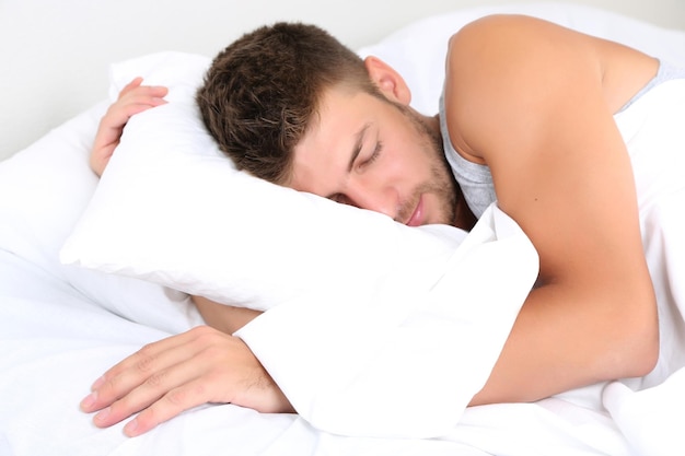 Handsome young man in bed