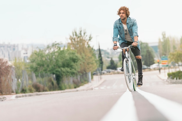 Photo handsome young man on bike in the city. bicycle concept