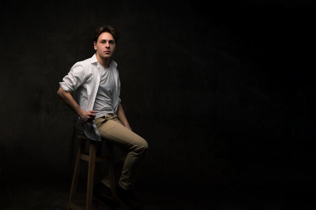 Handsome young man on black background looking at camera.