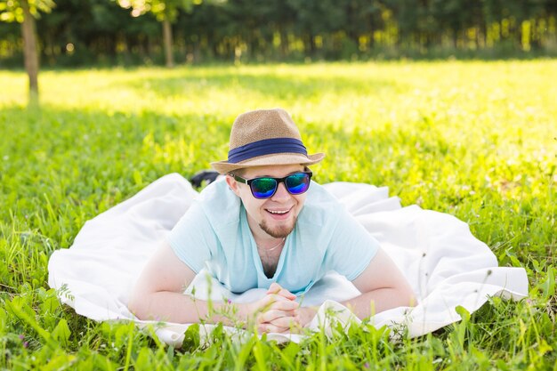 Handsome young man at countryside, in front of field wearing shirt, looking to camera smiling