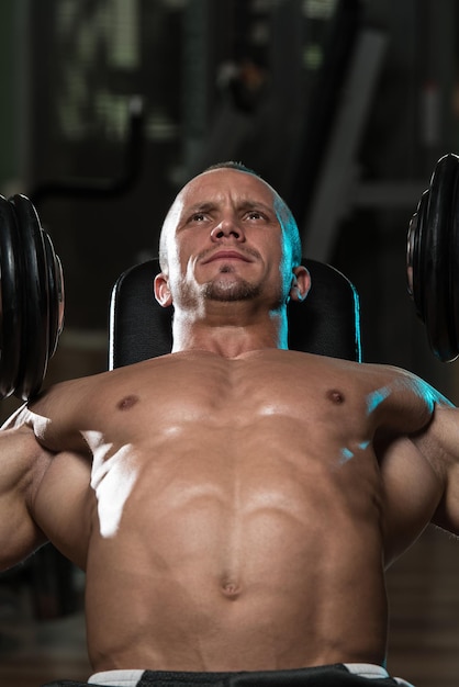 Handsome Young Man Doing Dumbbell Incline Bench Press Workout In Gym