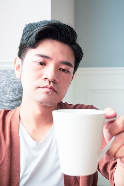 Handsome young man drinking at home