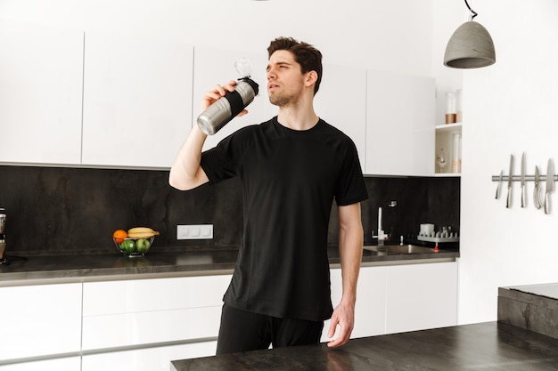 Handsome young man drinking water.