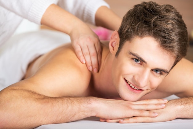 Photo handsome young man getting massage