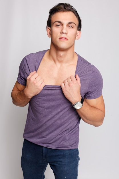 Handsome young man on grey background looking at camera