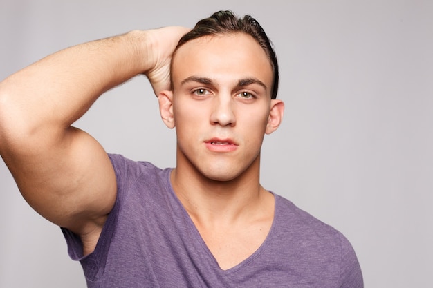 Handsome young man on grey background looking at camera