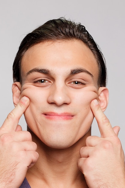 Handsome young man on grey background looking at camera