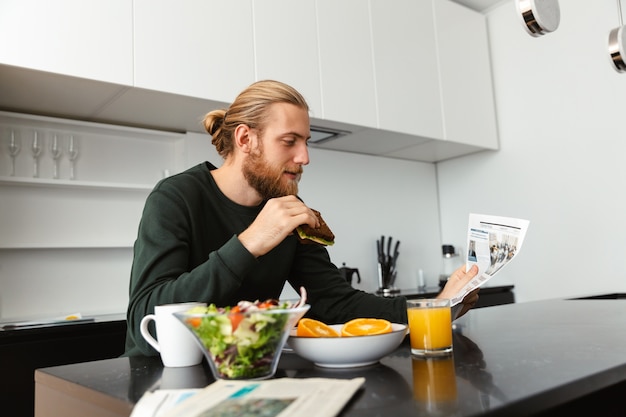 Handsome young man having breakfast