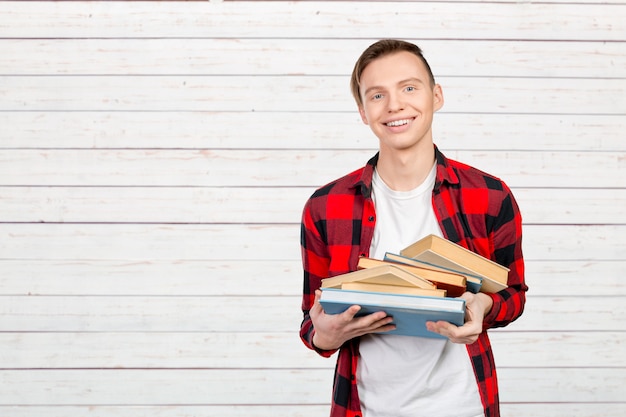 Handsome young man holding books