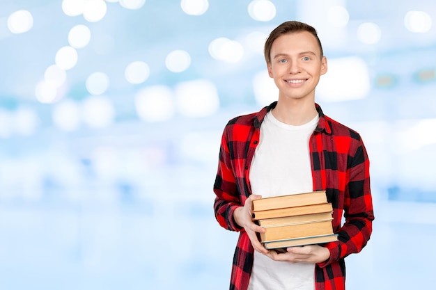 Handsome young man holding books