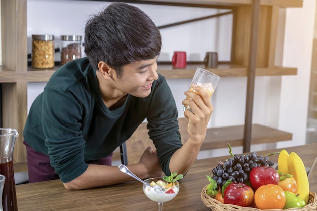 ハンサムな若い男はミルクティーを飲んで幸せです