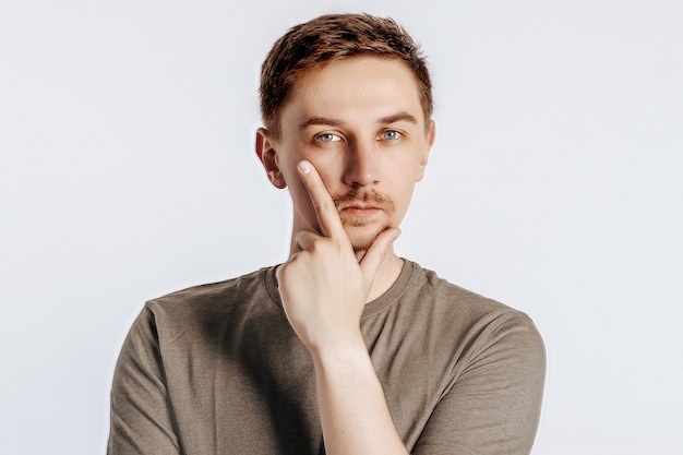 A handsome young man is thinking on white isolated background