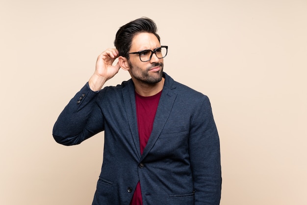 Handsome young man over isolated background having doubts