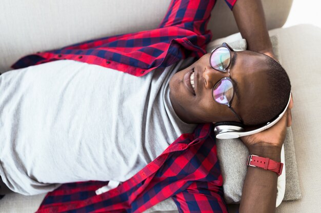 Handsome young man listening to music with headphones at home.