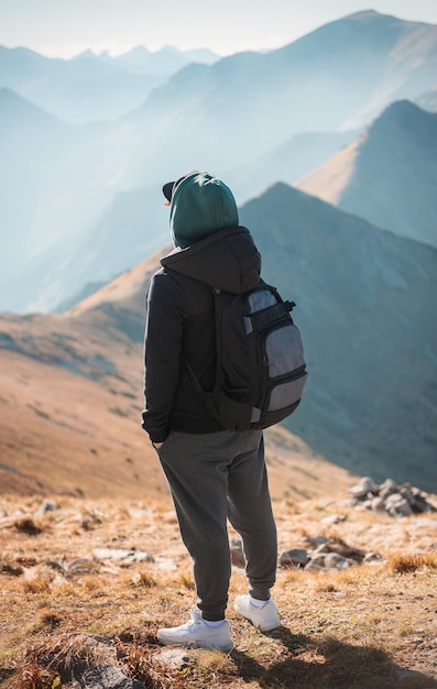 Handsome young man  looking away in front of mountain on sunny day.  Kasprowy Wierch. Poland.