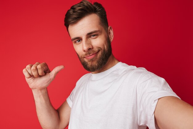 Handsome young man make a selfie looking camera pointing.