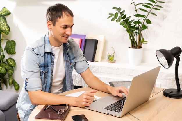 Giovane bello online utilizzando un computer portatile