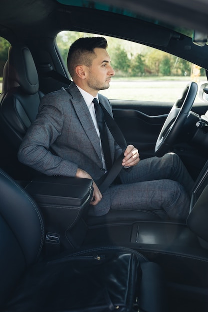 Handsome young man pinches seat belt