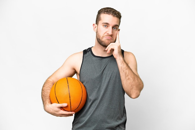 Handsome young man playing basketball over isolated white background thinking an idea