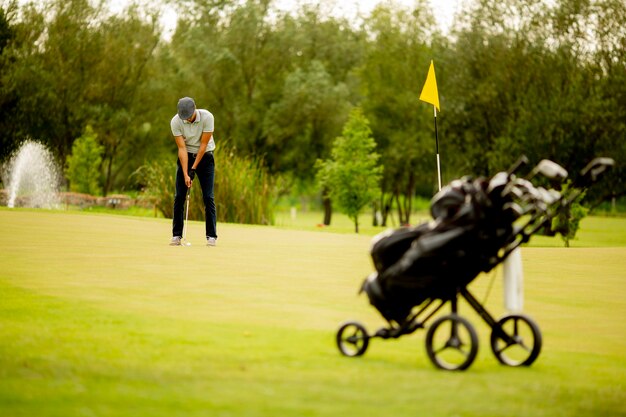 Handsome young man playing golf