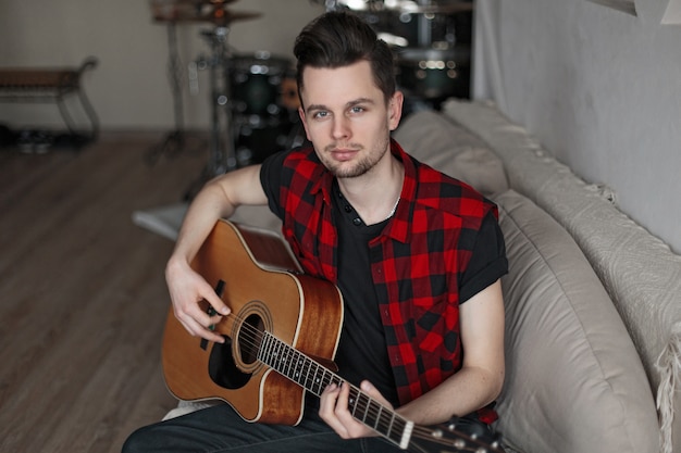 Handsome young man playing the guitar