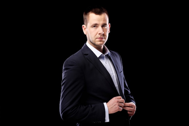 a handsome young man posing over black background