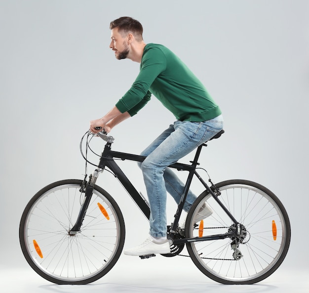 Handsome young man riding bicycle on light