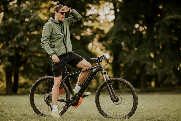 Handsome young man riding ebike in nature