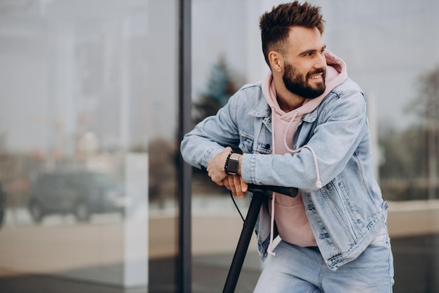 Handsome young man riding electric scooter