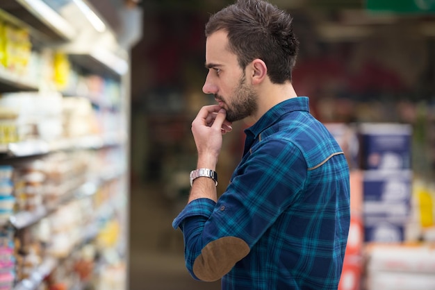 Foto bel giovane shopping per frutta e verdura nel reparto di prodotti di un supermercato supermercato poco profondo nel profondo del campo