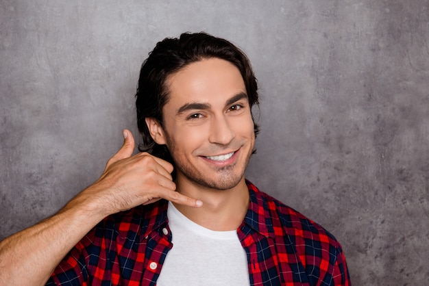 Handsome young man showing with fingers gesture "call me"