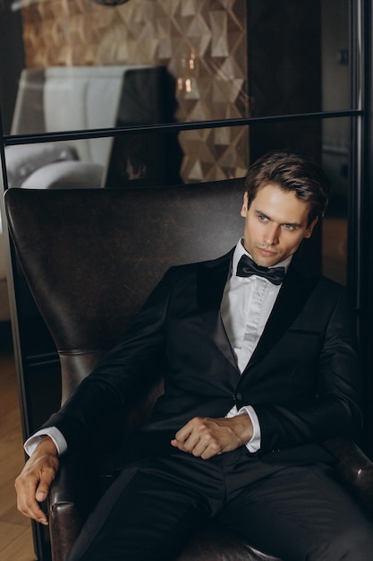 Handsome young man sitting on chair Fashionable Clothing Clothing for the festive evening