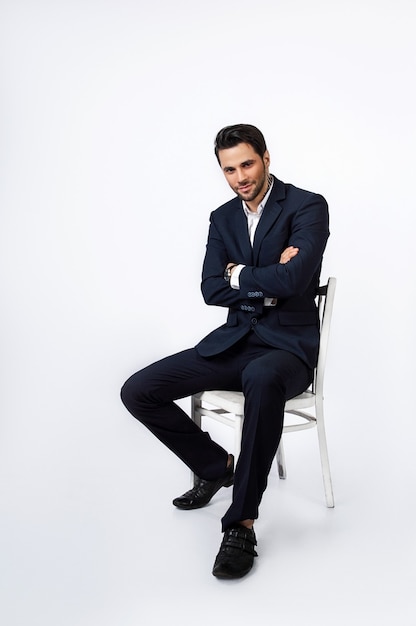 handsome young man sitting in a dark blue suit