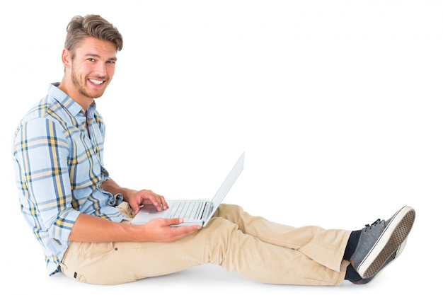 Photo handsome young man sitting using laptop