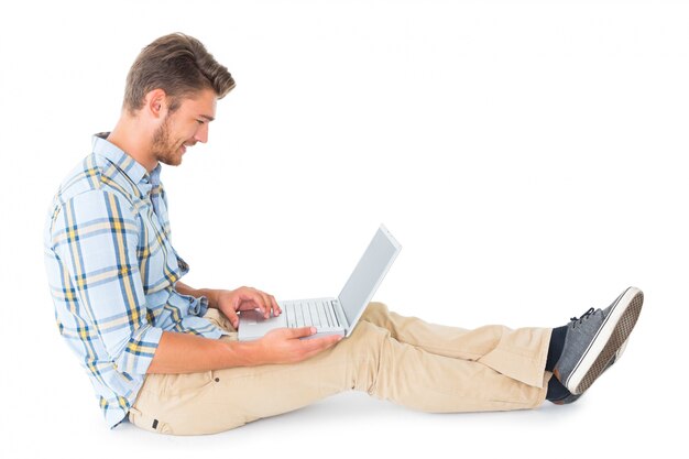 Handsome young man sitting using laptop