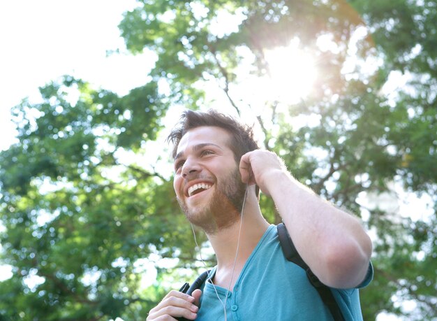 Handsome young man smiling with earphones outdoors