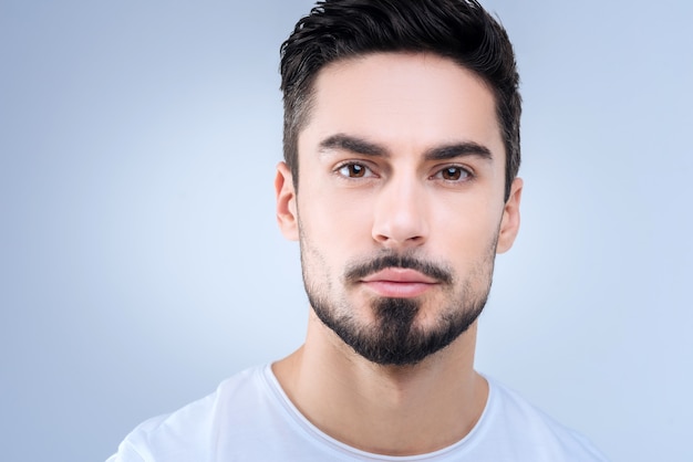 handsome young man standing against the blue wall