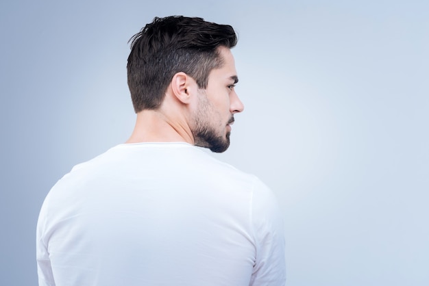 handsome young man standing against the blue wall